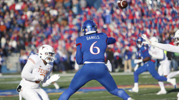 Kansas Jayhawks quarterback Jalon Daniels throws a pass while on the run in the first half against the Texas Longhorns in David Booth Kansas Memorial Stadium on November 19, 2022.